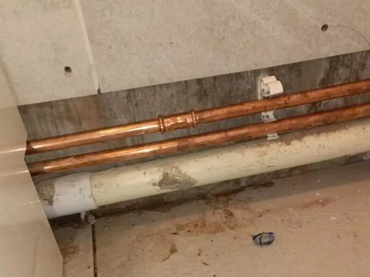 New copper pipe and press fittings running beside waste pipework below the basin area